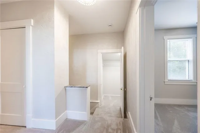 a view of a hallway with wooden floor and a cabinet