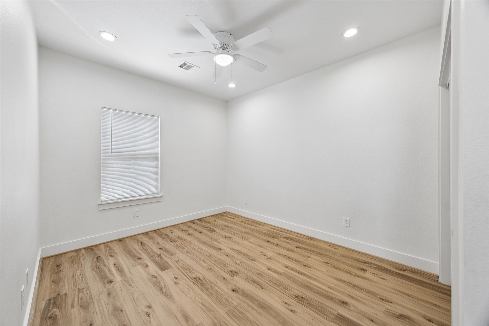 2749 Redrock Street, Unit B Houston, TX 77088 - Photo 18 of 24 The secondary bedroom has recessed lighting, a ceiling fan with light, window with blinds, luxury vinyl plank hardwood flooring, & a wardrobe closet to the right.