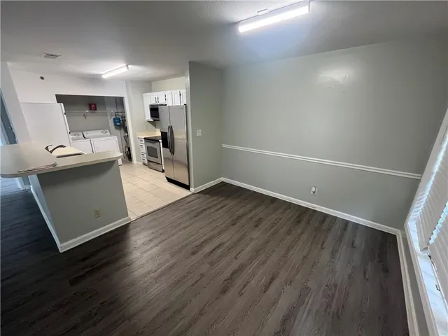 a view of a kitchen with furniture and wooden floor