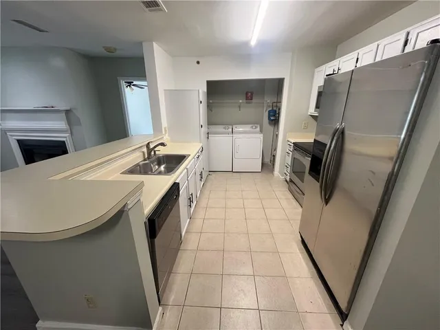 a kitchen with a sink a refrigerator and washer