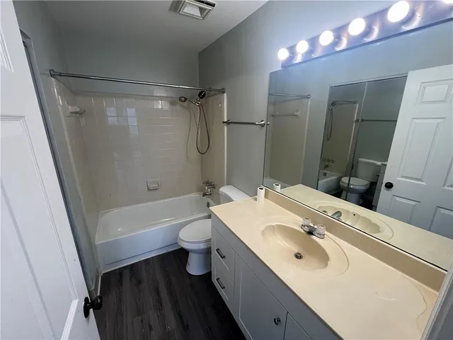 a bathroom with a sink toilet vanity and shower