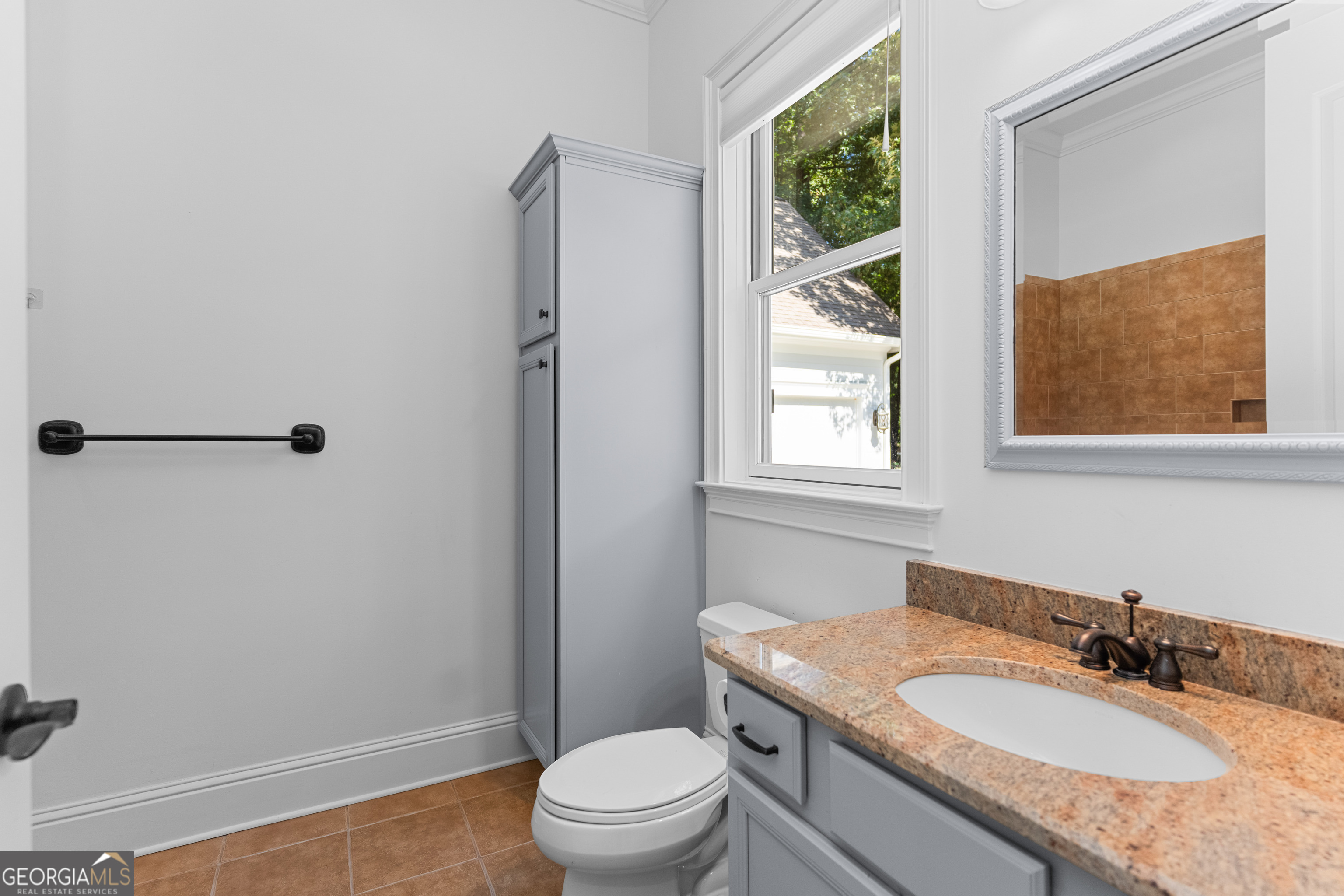 1011 Ridge Terrace Greensboro, GA 30642 - Photo 43 of 72 a bathroom with a granite countertop toilet a sink and a window