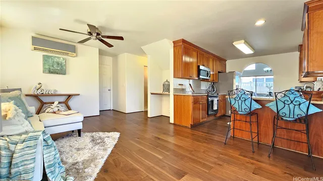 a living room with furniture kitchen view and a wooden floor