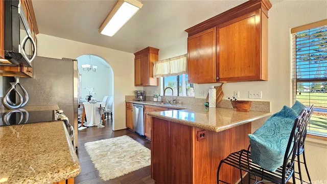 a kitchen with granite countertop sink stove and cabinets