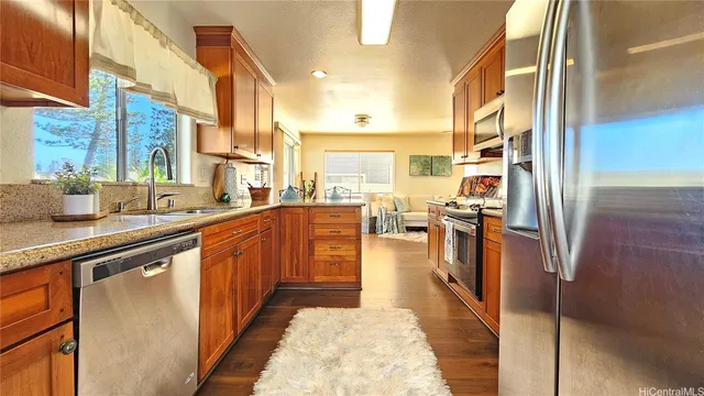 a large kitchen with stainless steel appliances kitchen island granite countertop a large counter top a stove and a refrigerator