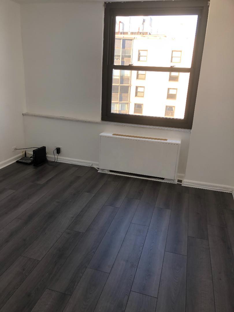 5701 North Sheridan Road, Unit 29T Chicago, IL 60660 - Photo 10 of 11 an empty room with wooden floor and windows