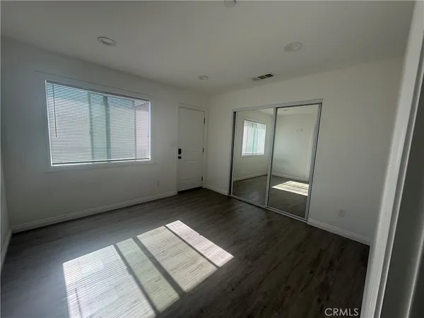 an empty room with wooden floor and mirror