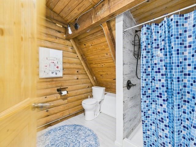 7386 Clint Court Athens, TX 75752 - Photo 35 of 40 a bathroom with a toilet and a shower curtain