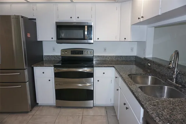 a kitchen with a refrigerator stove and cabinets