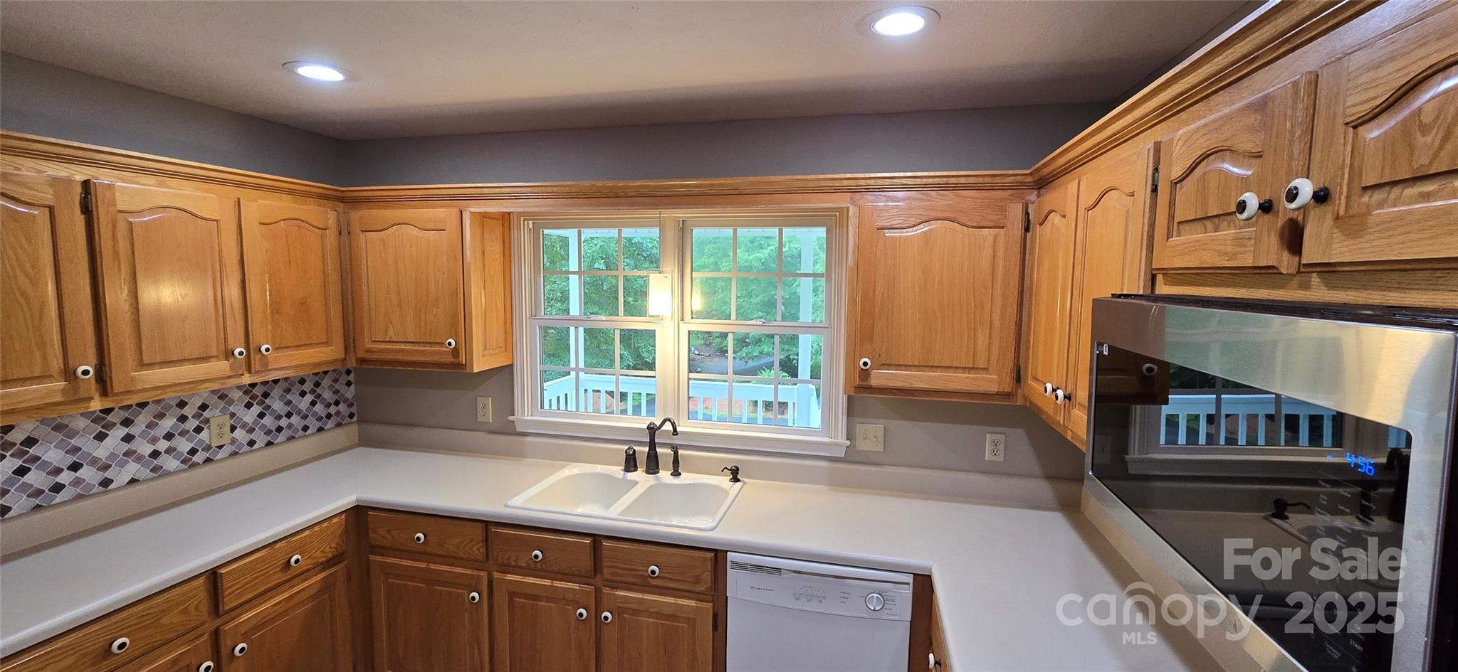 221 Flat Branch Trail Mill Spring, NC 28756 - Photo 12 of 32 a kitchen with sink a window and cabinets
