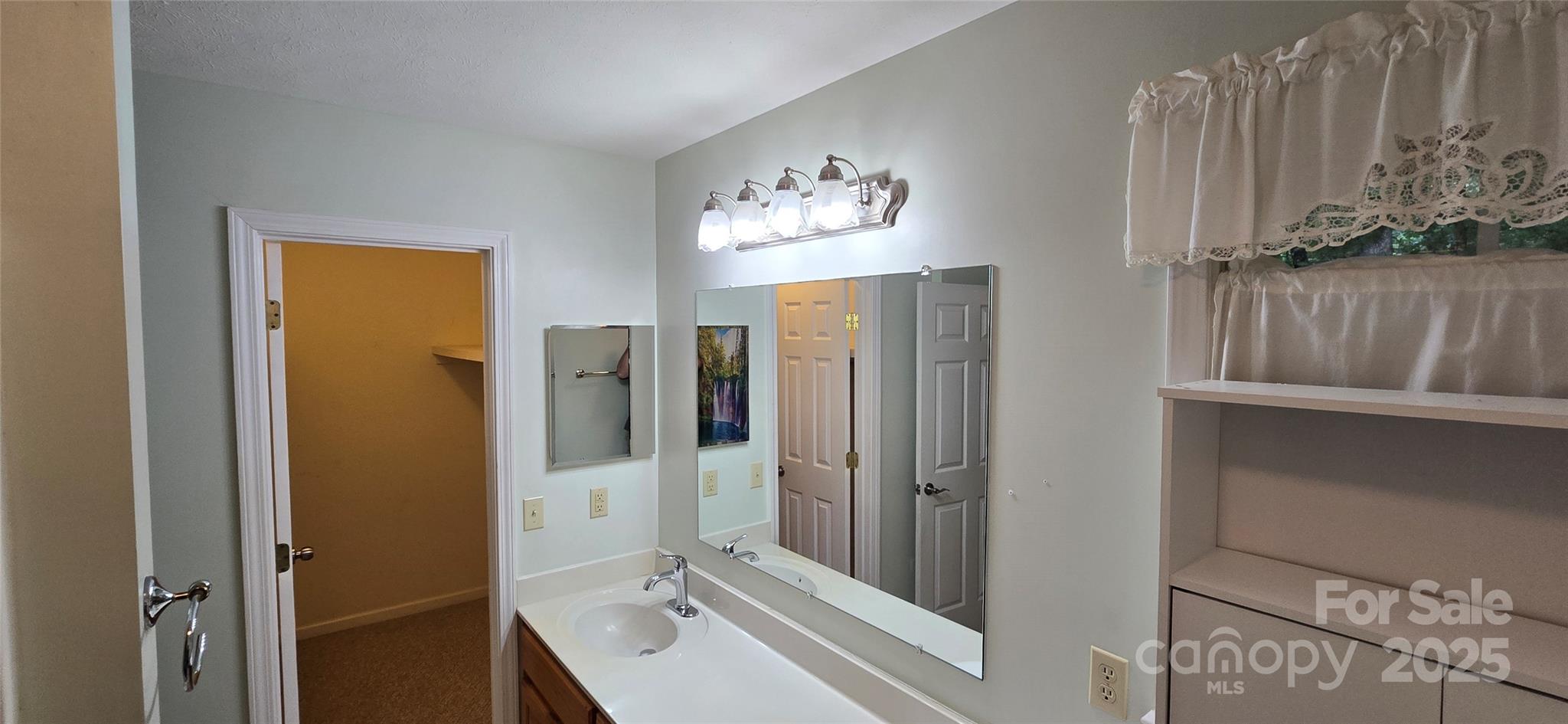 221 Flat Branch Trail Mill Spring, NC 28756 - Photo 18 of 32 a bathroom with a double vanity sink and a mirror