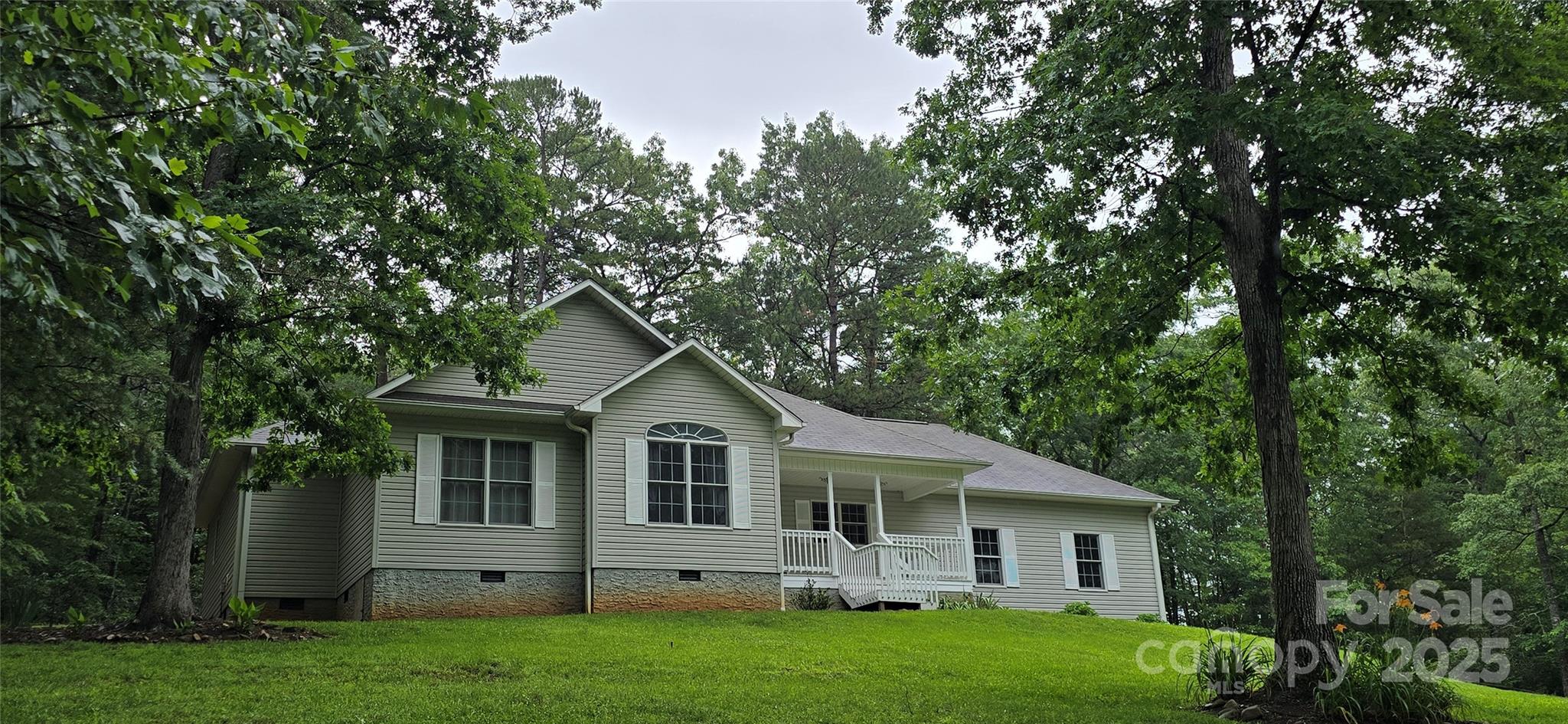 221 Flat Branch Trail Mill Spring, NC 28756 - Photo 2 of 32 a front view of a house with a garden