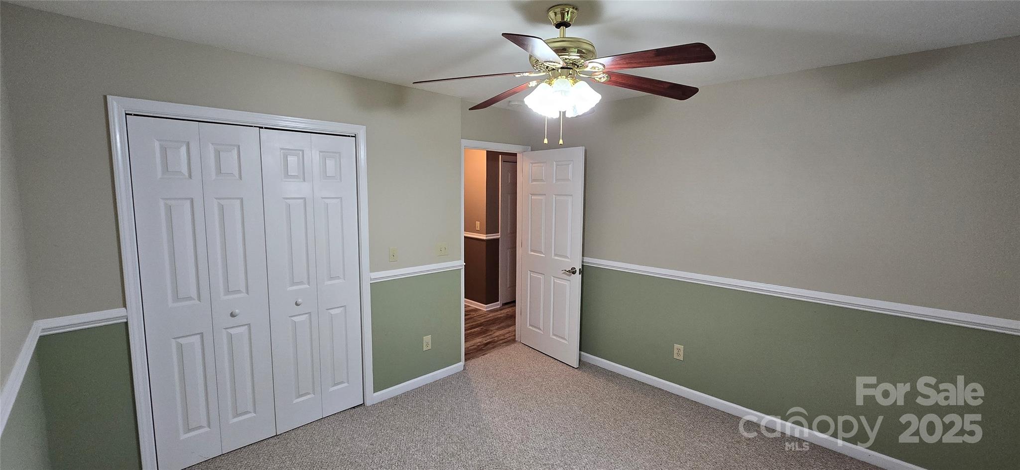 221 Flat Branch Trail Mill Spring, NC 28756 - Photo 22 of 32 an empty room with closet and a chandelier fan