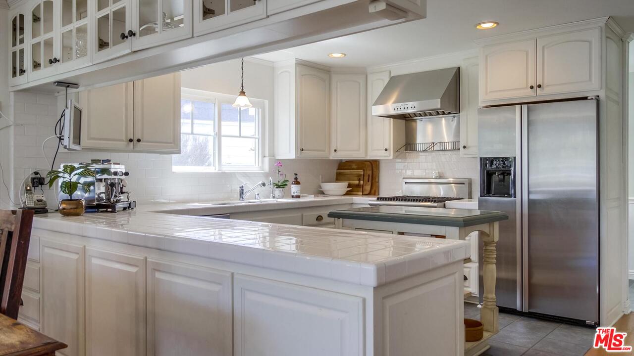 29500 Heathercliff Road, Unit 119 Malibu, CA 90265 - Photo 14 of 47 a kitchen with stainless steel appliances granite countertop a sink a refrigerator and white cabinets