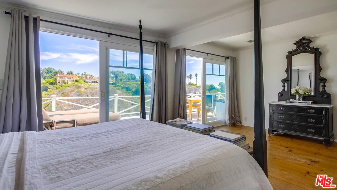 29500 Heathercliff Road, Unit 119 Malibu, CA 90265 - Photo 17 of 47 a bedroom with a bed and large windows