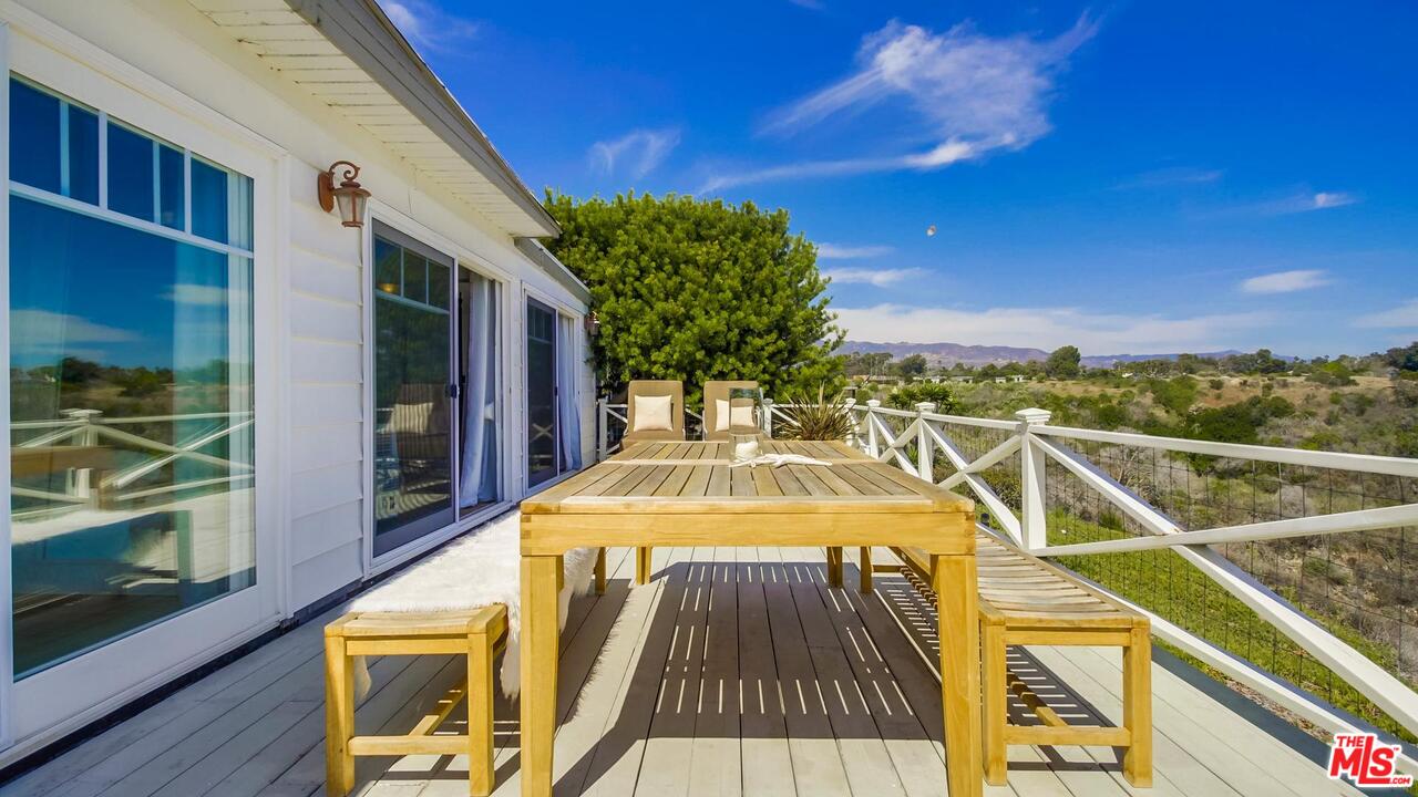 29500 Heathercliff Road, Unit 119 Malibu, CA 90265 - Photo 33 of 47 a view of a balcony with floor to ceiling windows with wooden floor