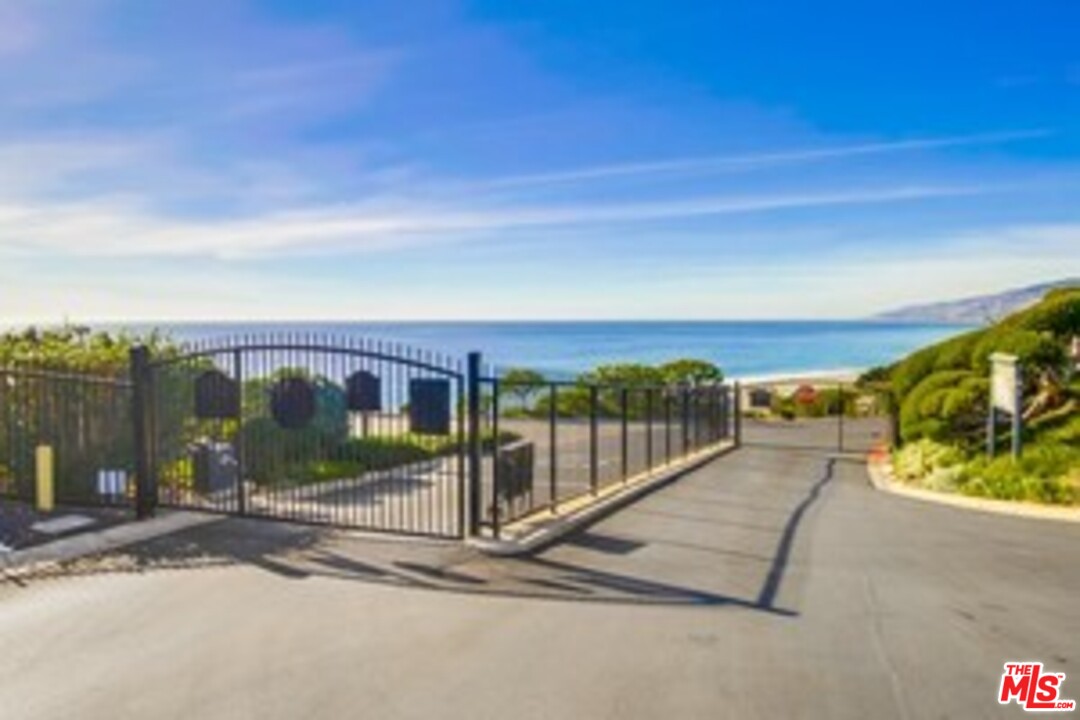 29500 Heathercliff Road, Unit 119 Malibu, CA 90265 - Photo 46 of 47 a view of a pathway with a wrought fence