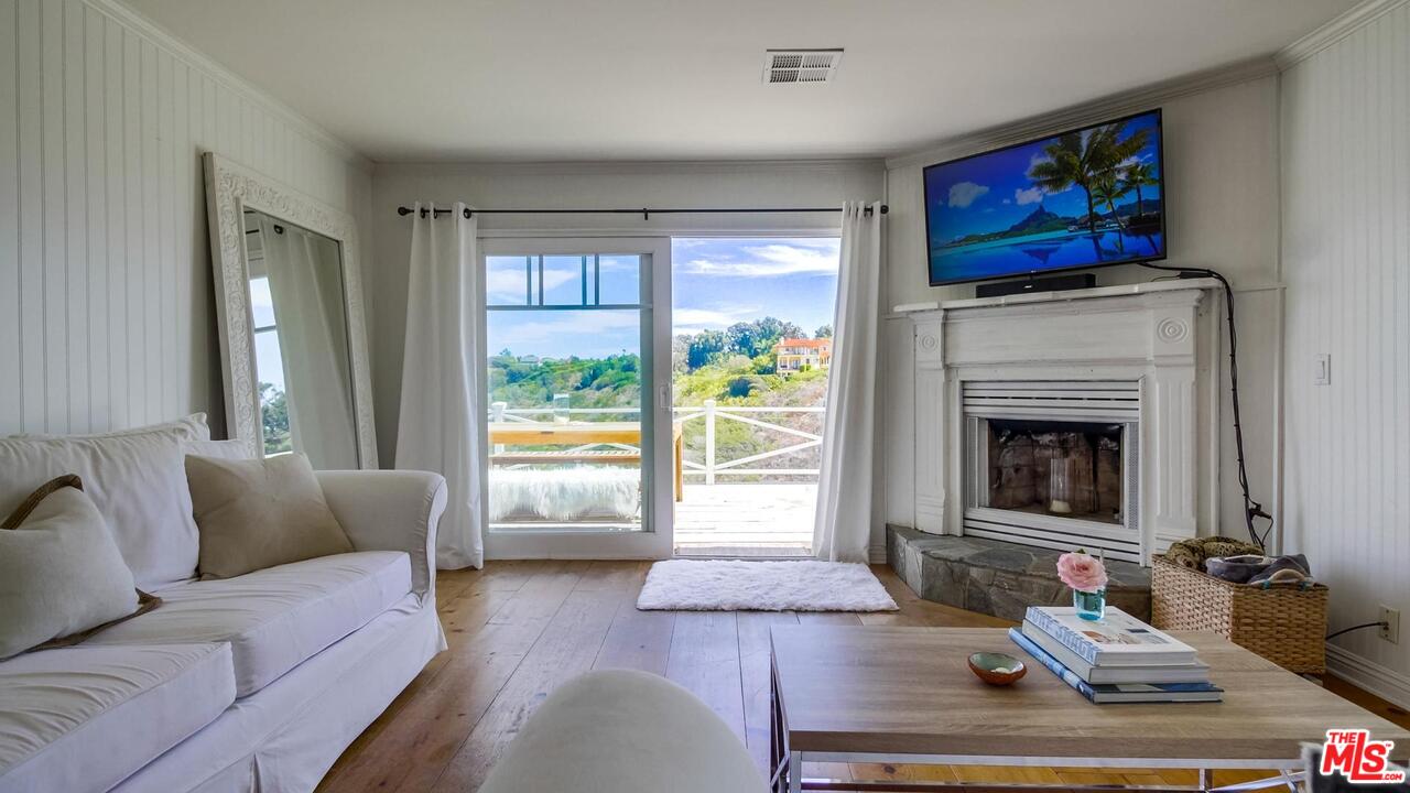 29500 Heathercliff Road, Unit 119 Malibu, CA 90265 - Photo 9 of 47 a living room with furniture and a fireplace