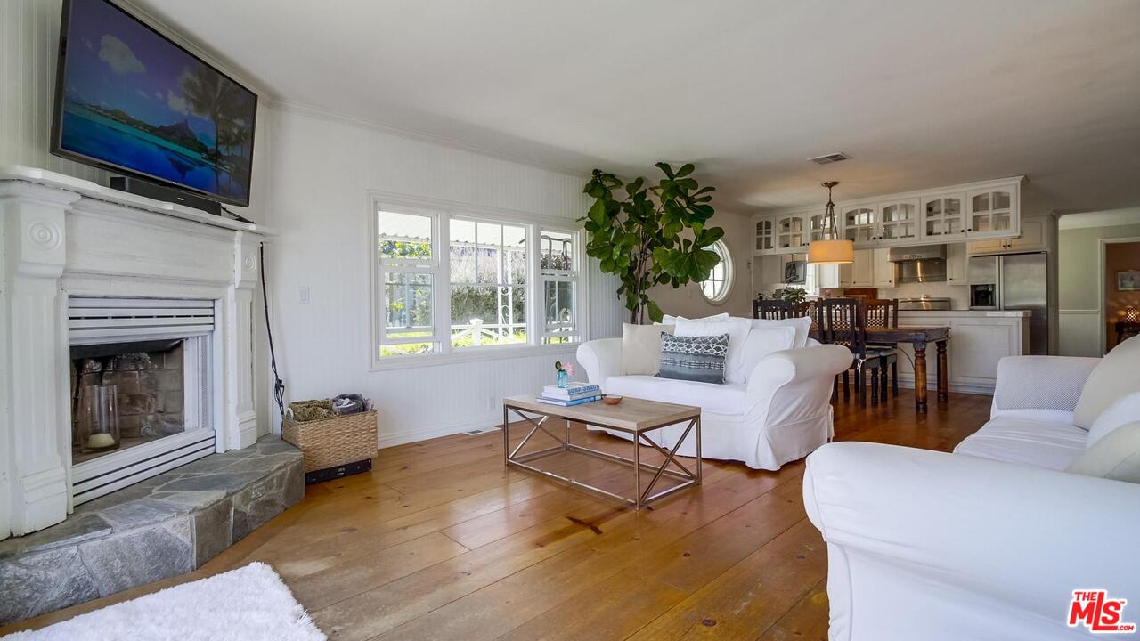 29500 Heathercliff Road, Unit 119 Malibu, CA 90265 - Photo 10 of 47 a living room with furniture a flat screen tv and a fireplace