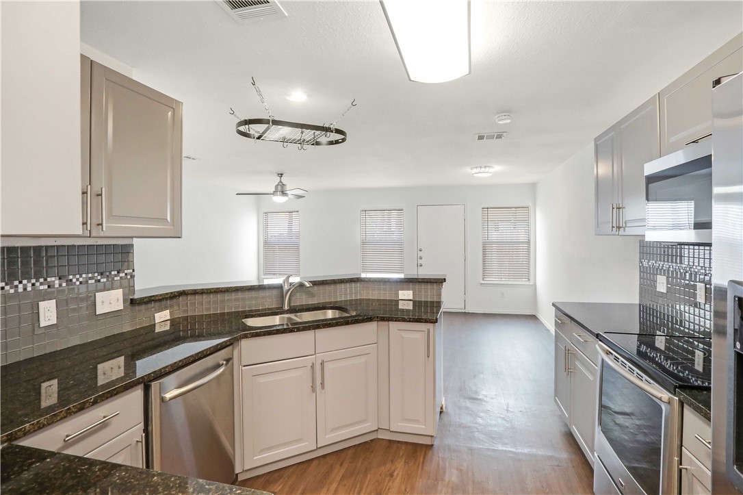 9614 Nightjar Drive, Unit A Austin, TX 78748 - Photo 14 of 34 a kitchen with granite countertop a sink a stove and cabinets