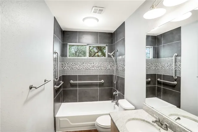 a bathroom with a sink a toilet and shower