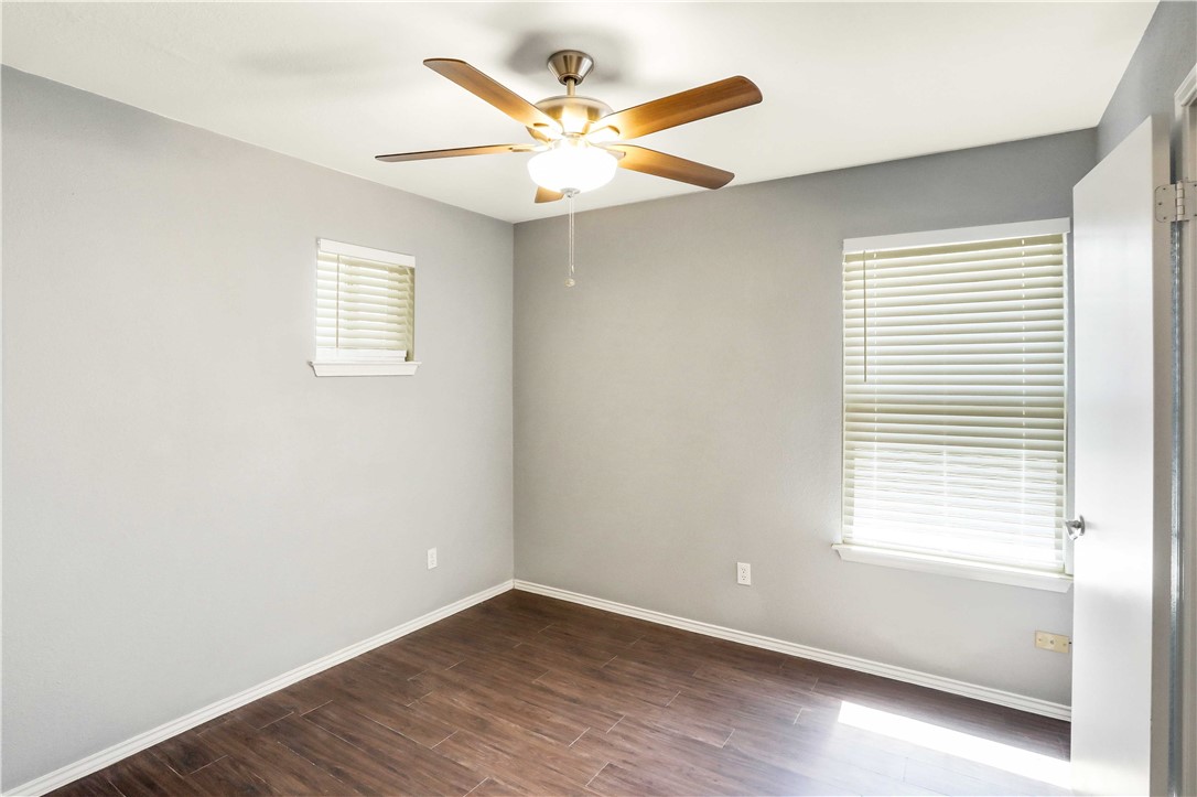 9614 Nightjar Drive, Unit A Austin, TX 78748 - Photo 29 of 34 an empty room with wooden floor fan and windows