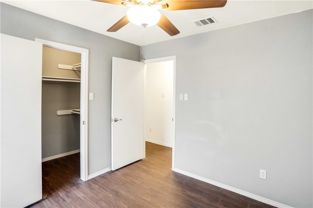 9614 Nightjar Drive, Unit A Austin, TX 78748 - Photo 30 of 34 an empty room with wooden floor and a ceiling fan