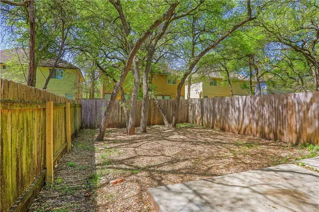 a view of a backyard with wooden fence