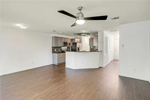 a view of a kitchen with a sink and wooden floor