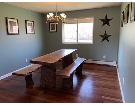 205 Podunk Road Sturbridge, MA 01566 - Photo 11 of 30 a dining room with wooden floor a chandelier a wooden table and chairs