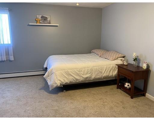 205 Podunk Road Sturbridge, MA 01566 - Photo 15 of 30 a bedroom with a bed and a lamp
