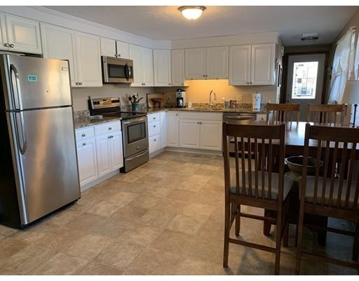 205 Podunk Road Sturbridge, MA 01566 - Photo 21 of 30 a kitchen with granite countertop a refrigerator a stove a dining table and chairs