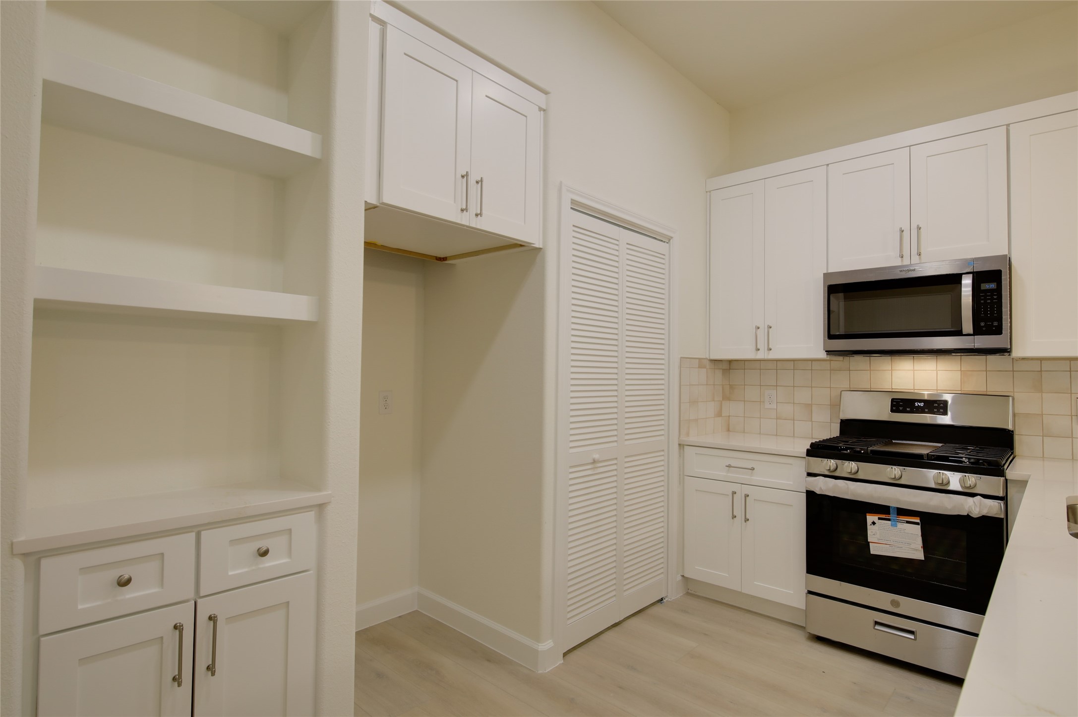 955 Ringold Street Houston, TX 77088 - Photo 13 of 48 a kitchen with white cabinets and stainless steel appliances