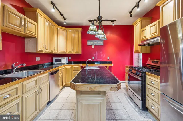 a kitchen with stainless steel appliances granite countertop a stove sink and cabinets