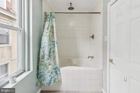 a bathroom with a shower curtain and a window