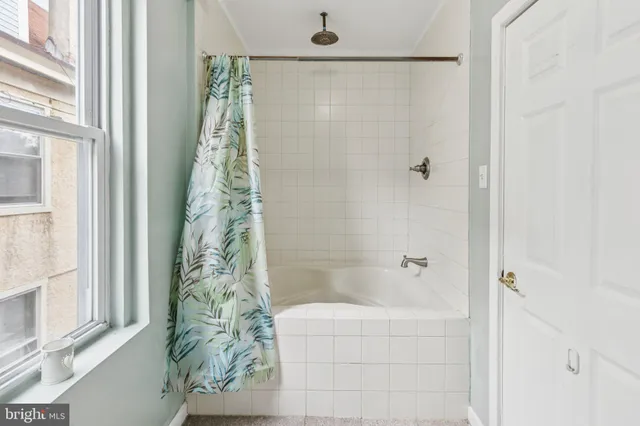 a bathroom with a shower curtain and a window