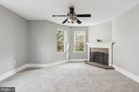 a view of empty room with fireplace and windows