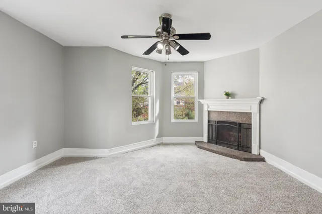 a view of empty room with fireplace and windows