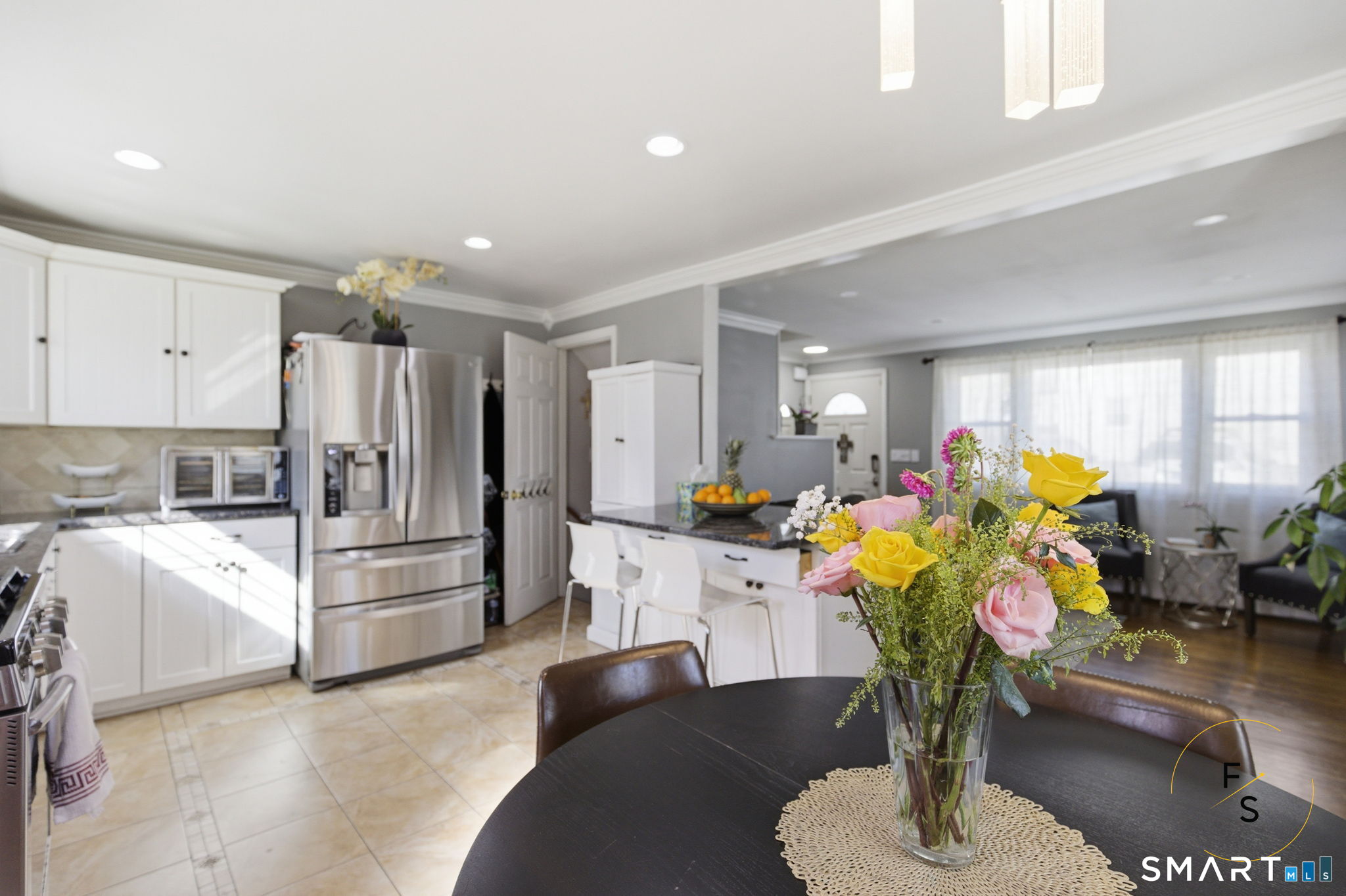 1 Phillips Street, Unit 4 Norwalk, CT 06850 - Photo 5 of 35 a kitchen with stainless steel appliances kitchen island granite countertop a refrigerator a stove a sink a dining table and chairs with wooden floor