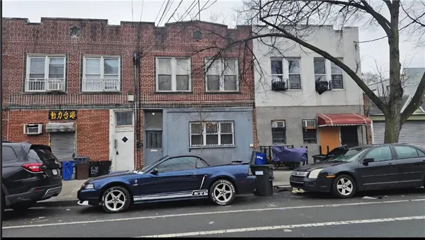 a car parked in front of a big house