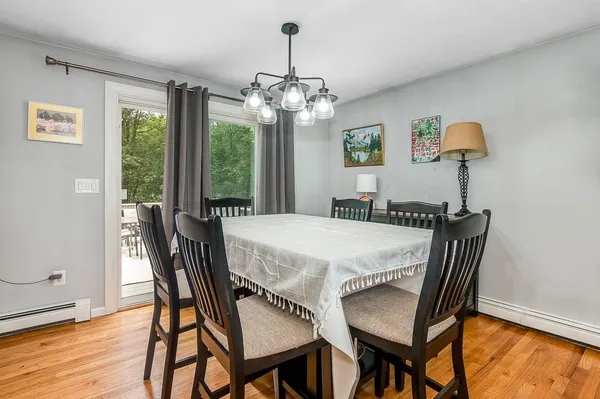 a dining room with furniture a chandelier and wooden floor