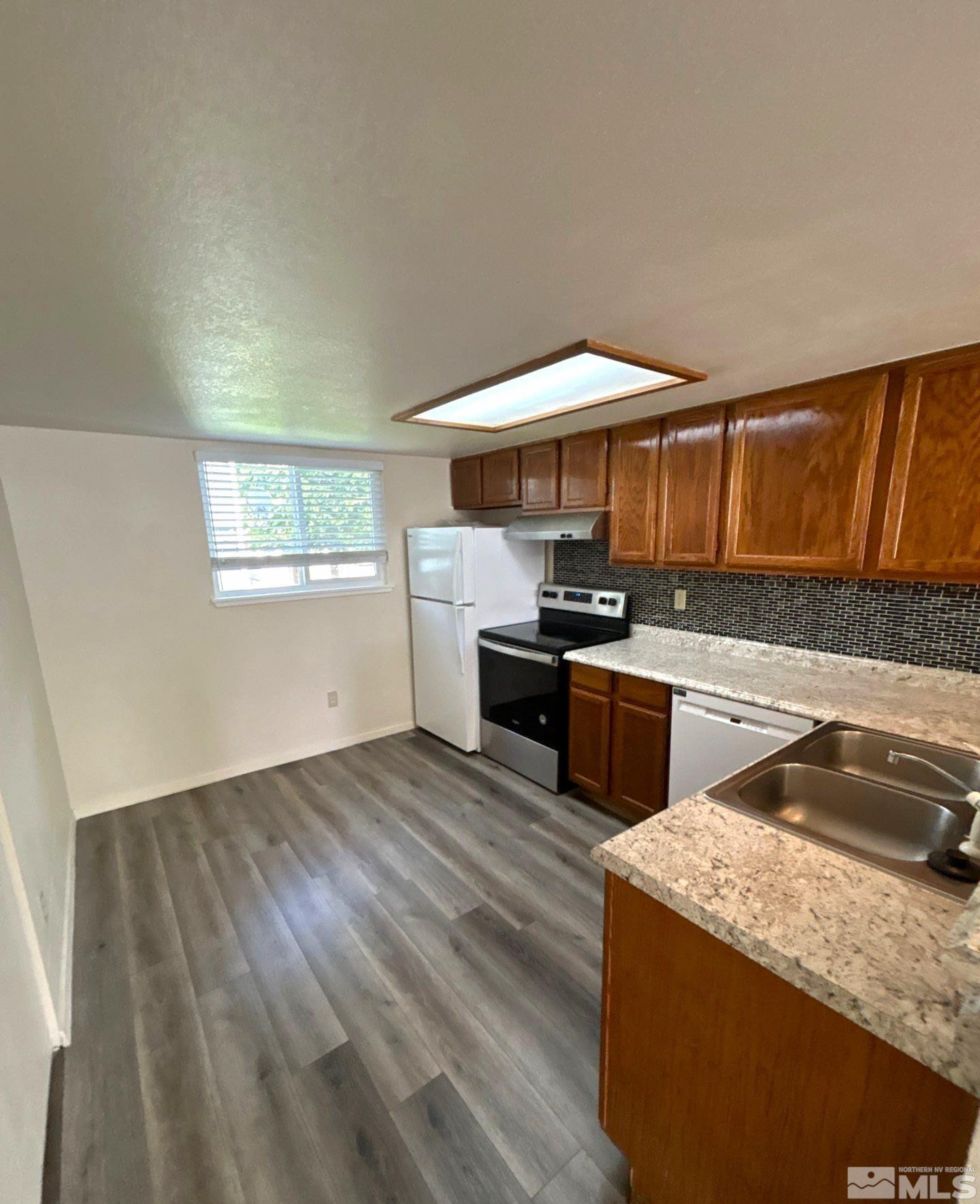 3673 Grant Drive, Unit C Reno, NV 89509 - Photo 4 of 15 a kitchen with granite countertop a sink and a stove top oven