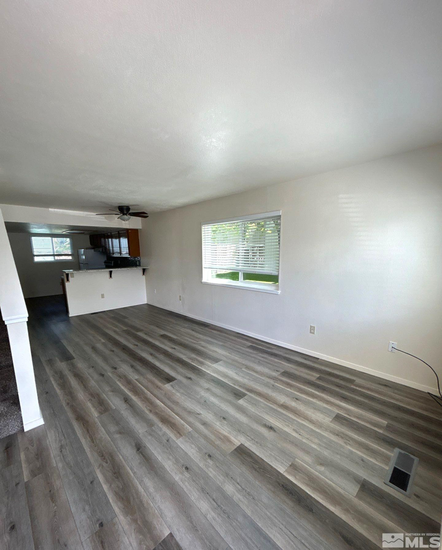 3673 Grant Drive, Unit C Reno, NV 89509 - Photo 5 of 15 a view of empty room with wooden floor and window