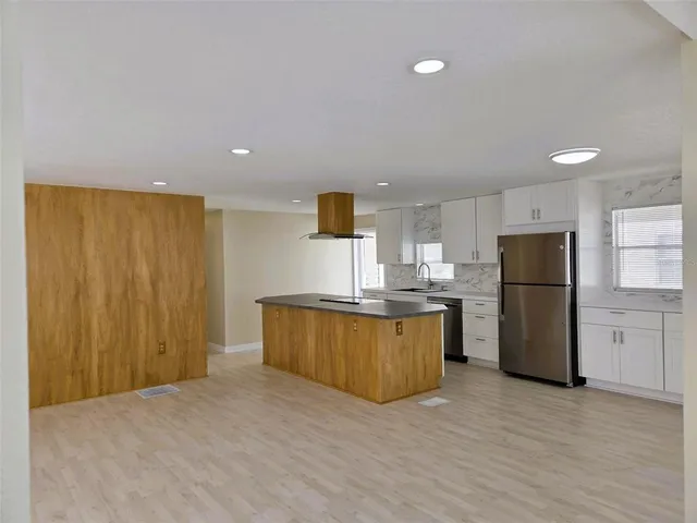a kitchen with stainless steel appliances a refrigerator and a stove top oven