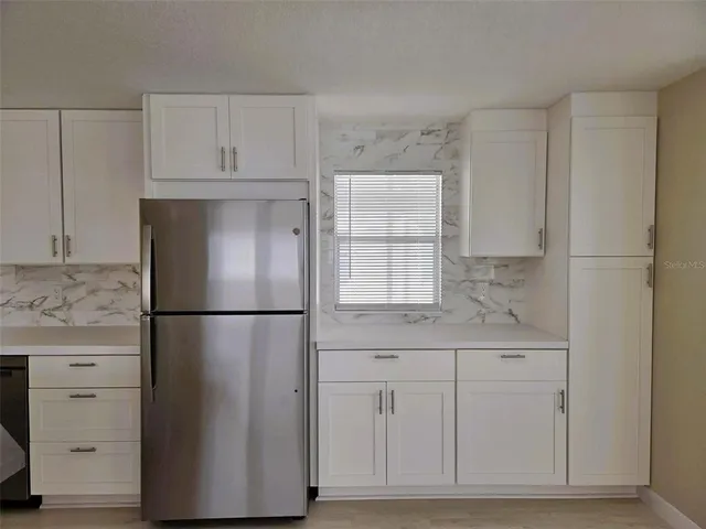 a white refrigerator freezer sitting inside of a kitchen