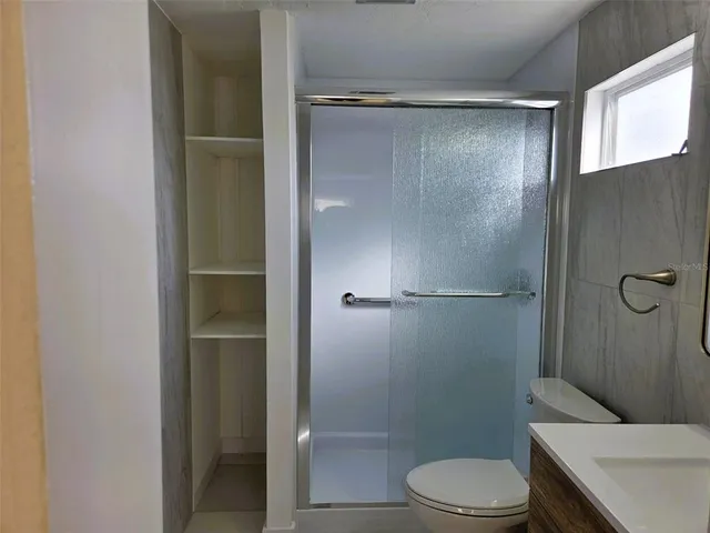 a bathroom with a shower a toilet and a sink