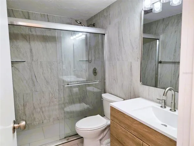 a bathroom with a sink a toilet and shower