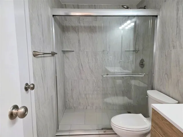 a bathroom with a shower a toilet and a sink
