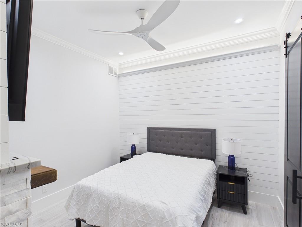 3650 Sunset Boulevard Naples, FL 34112 - Photo 20 of 26 Bedroom featuring a shiplap accent wall, crown molding, and recessed lighting