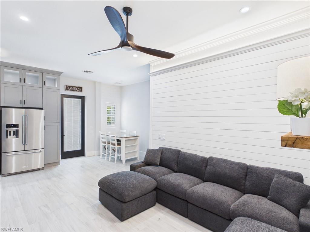 3650 Sunset Boulevard Naples, FL 34112 - Photo 3 of 26 Open-concept living area with shiplap accent wall, light wood-finish flooring, recessed lighting, and a modern ceiling fan